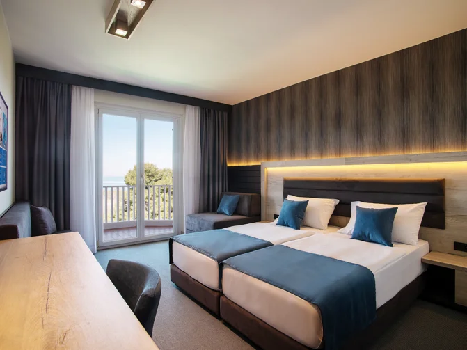 Prostorna hotelska soba lesenega videza in modrih odtenkov