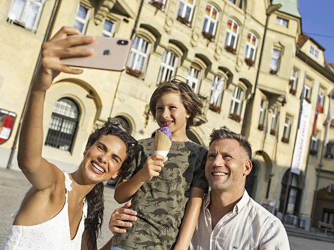 Tričlanska družina v starem jedru mesta Ptuj se fotografira